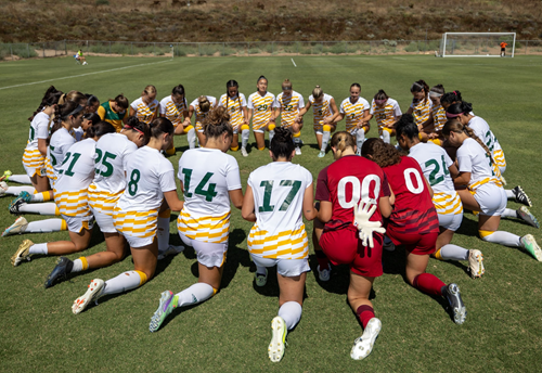Women's Soccer team huddled together in prayer